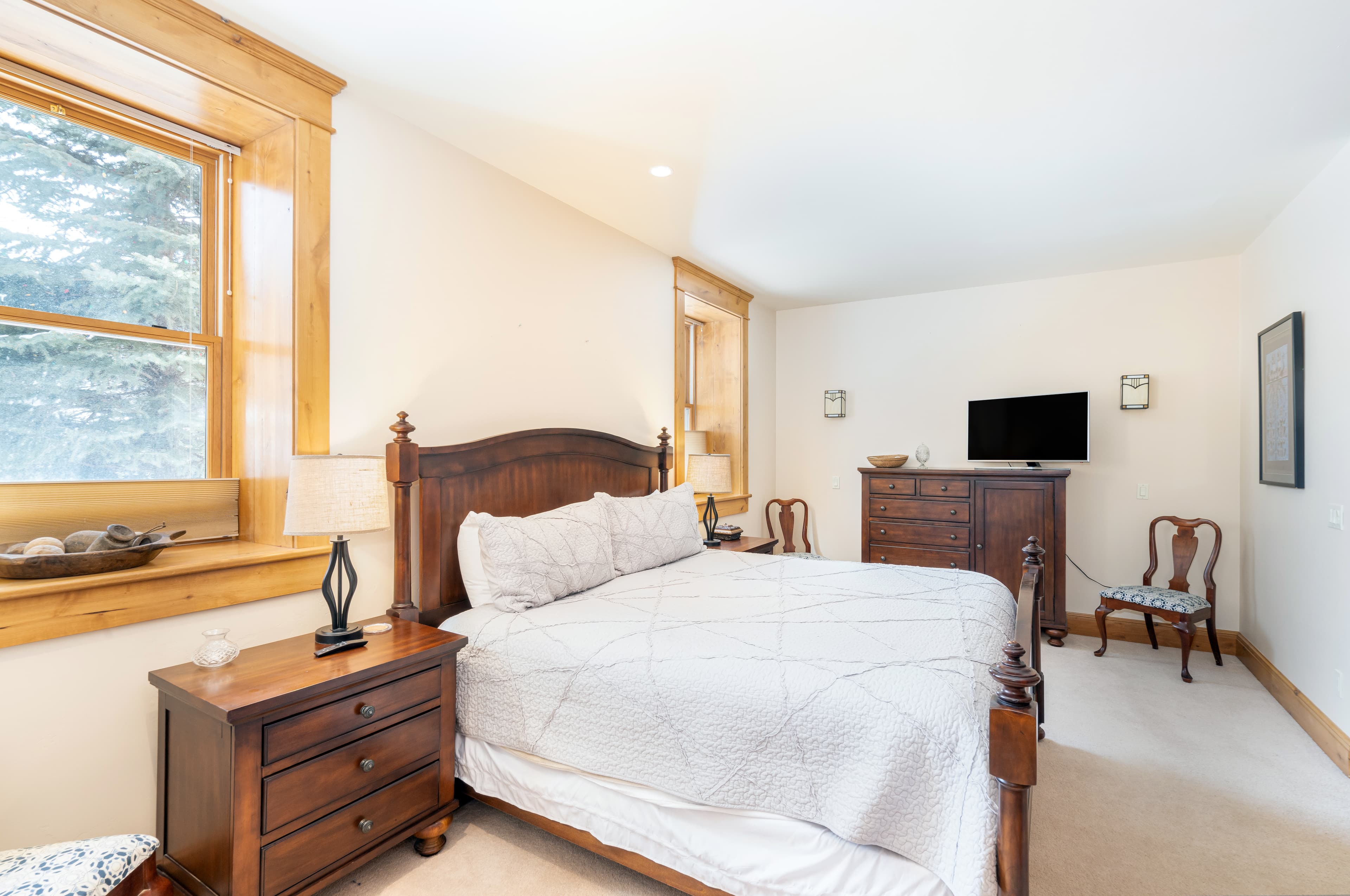 Primary bedroom with dresser and HD TV