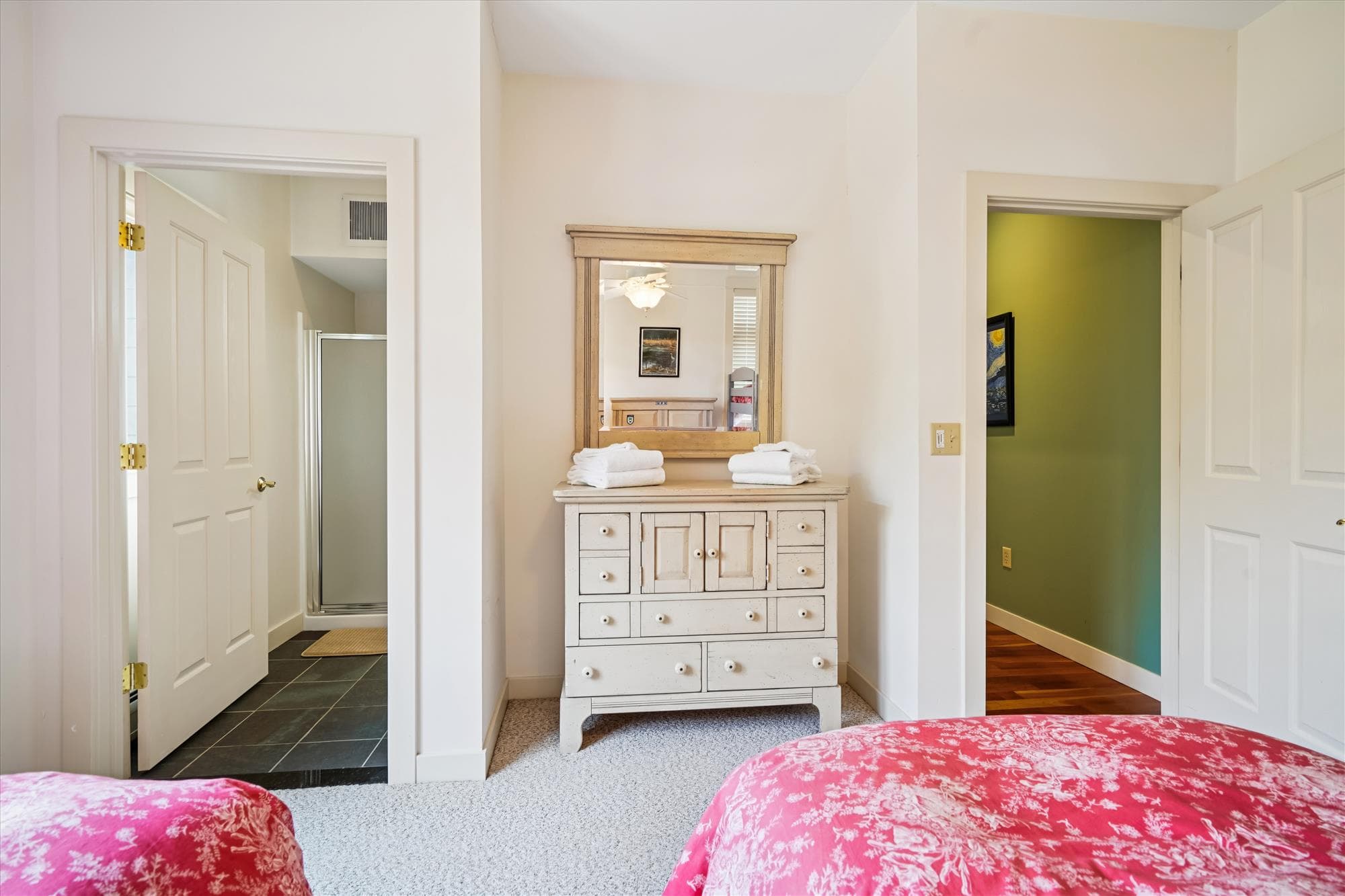 Bedroom with two twin beds and a bunk set, perfect for families or groups. Bright and welcoming with an attached bathroom.