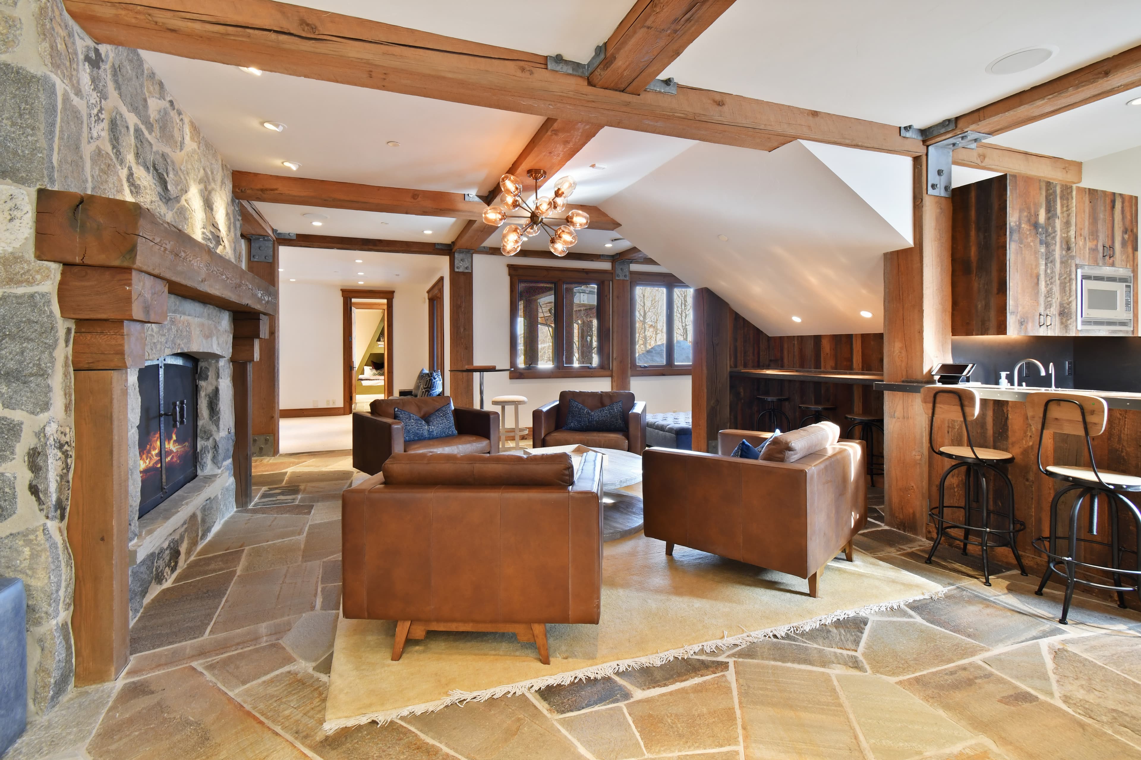 A fireplace flanks four armchairs, surrounding a granite coffee table.
