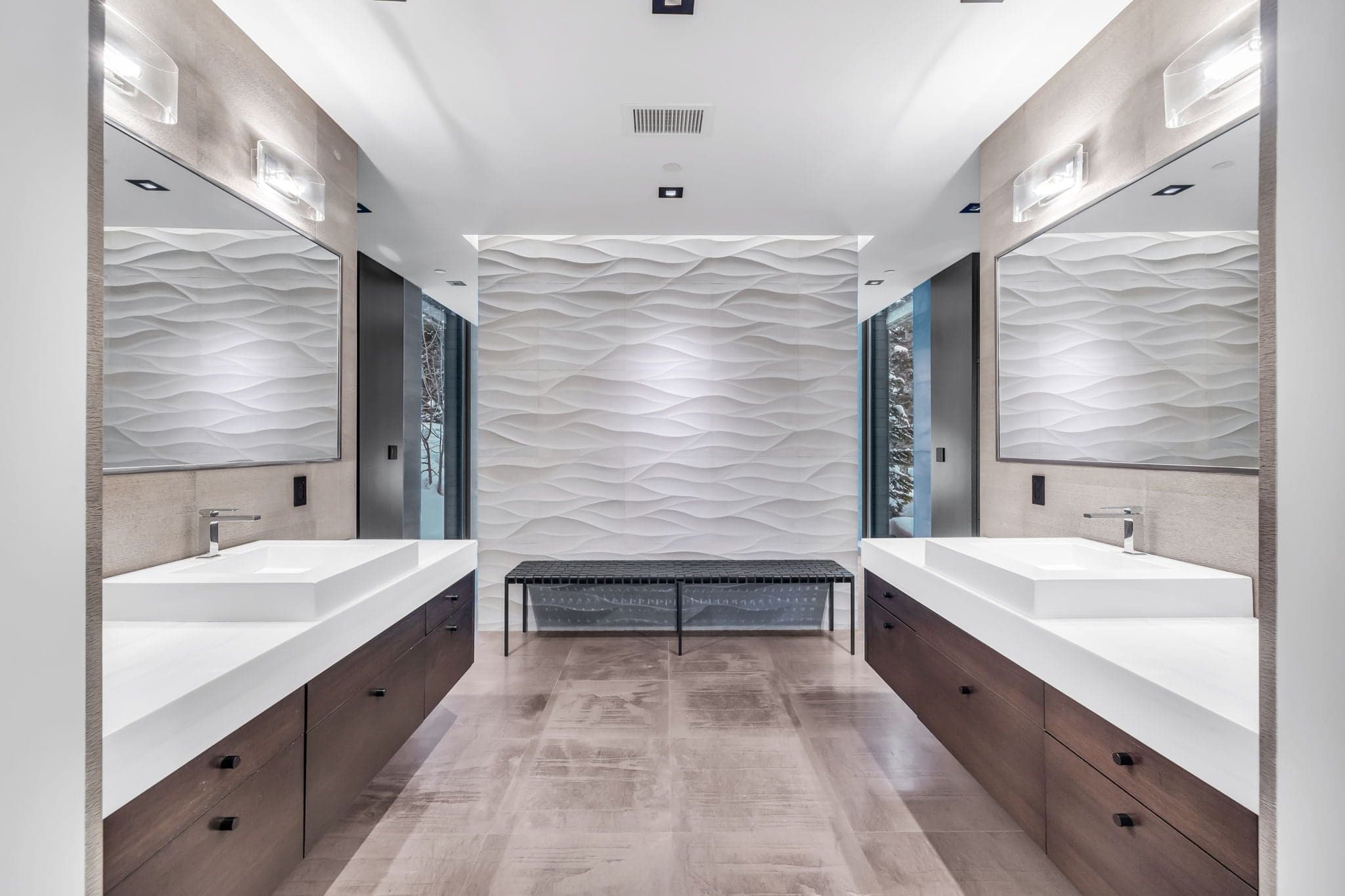 A modern bathroom with dual vanities and elegant textures.