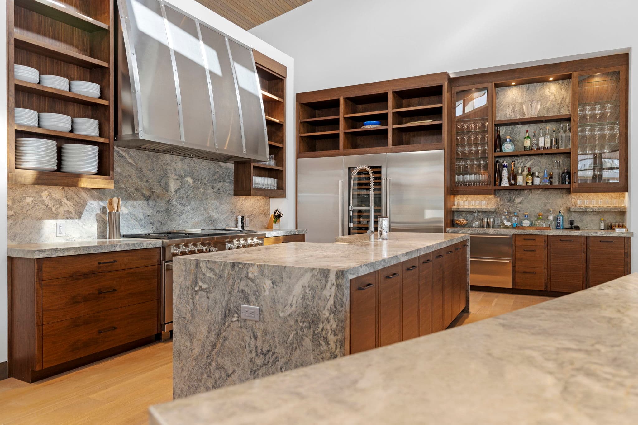 The kitchen with a large island and stainless-steel refrigerator.