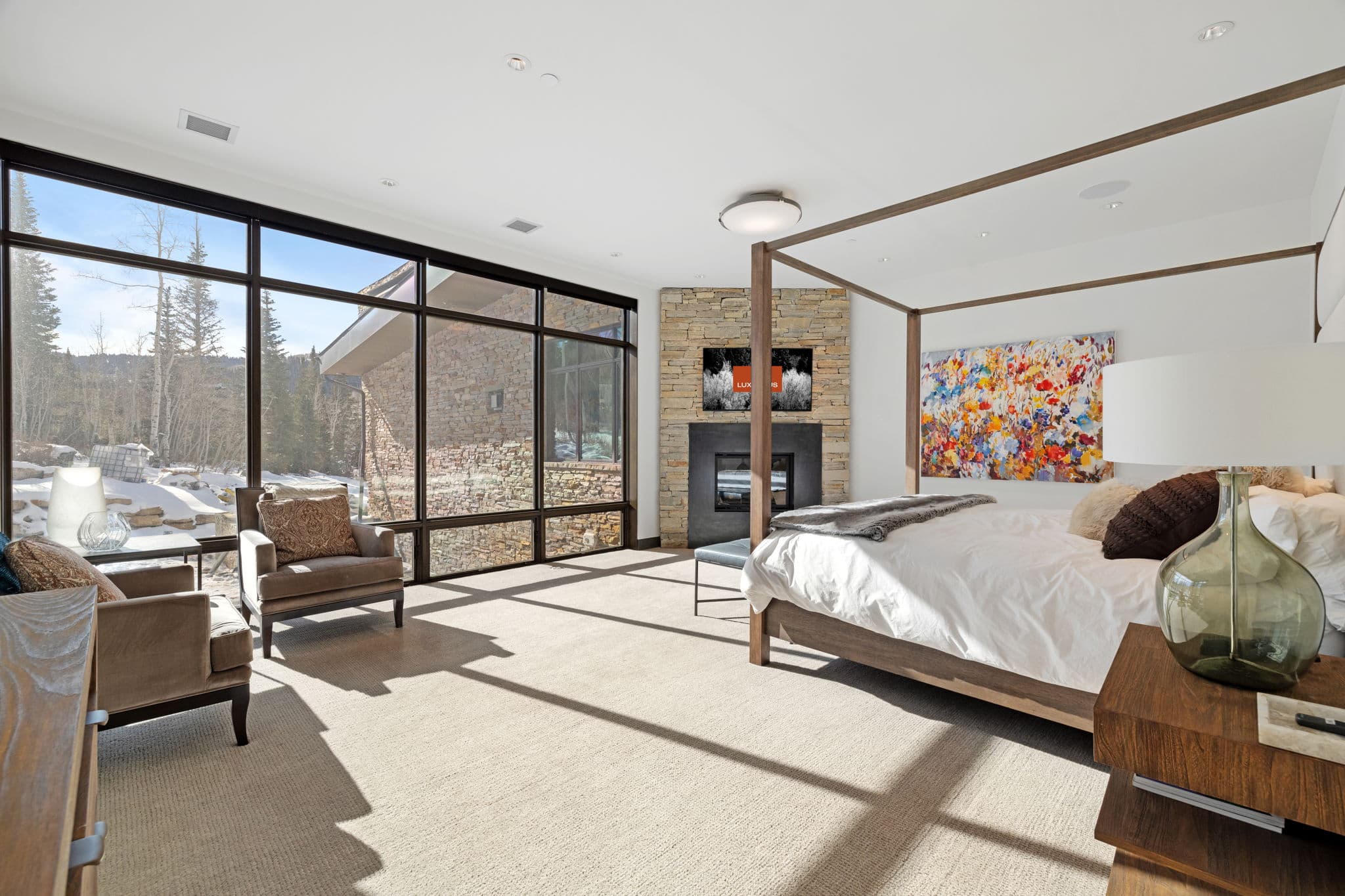 A bedroom with a four-post bed and a fireplace.
