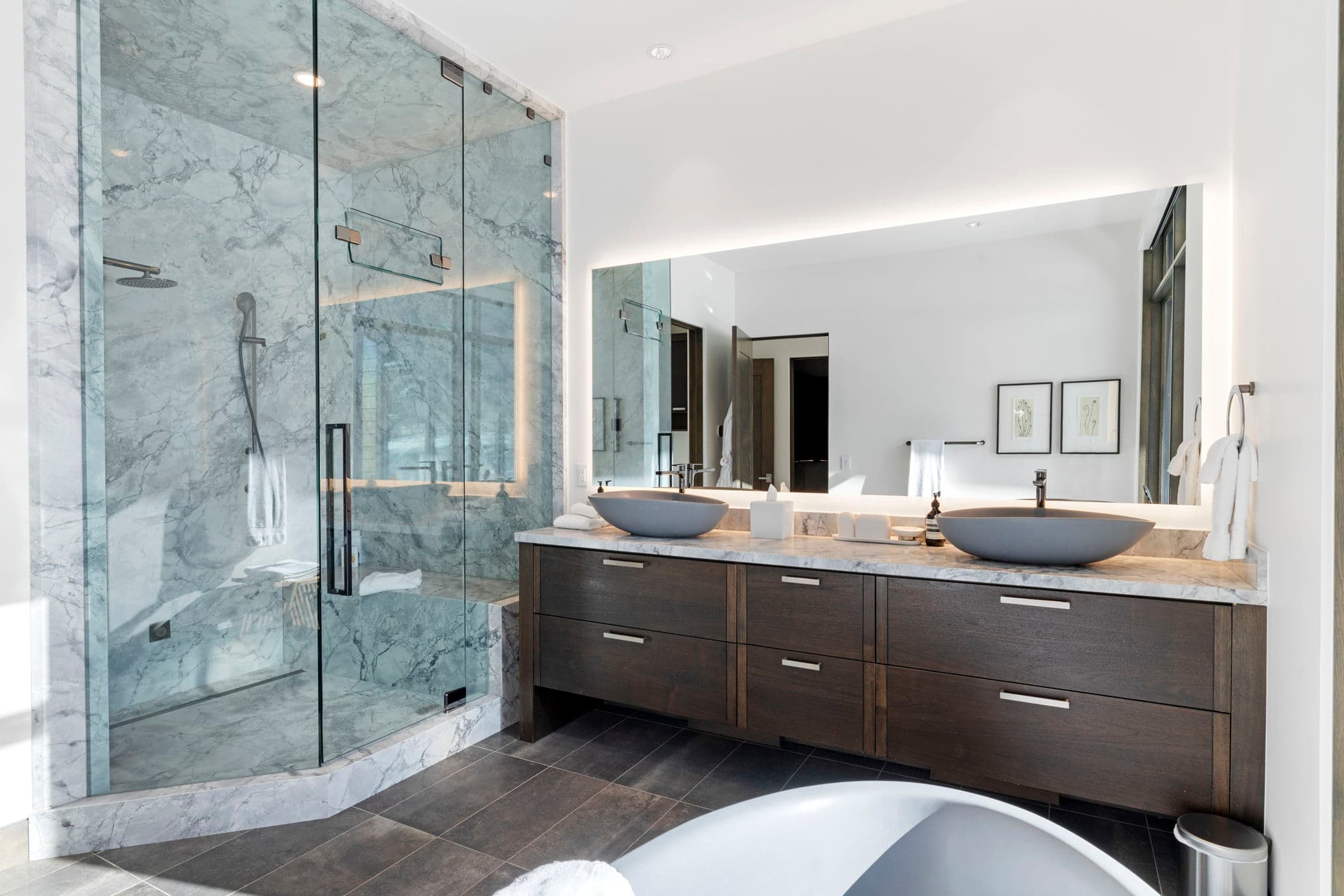 A bathroom with twin sinks and a shower.
