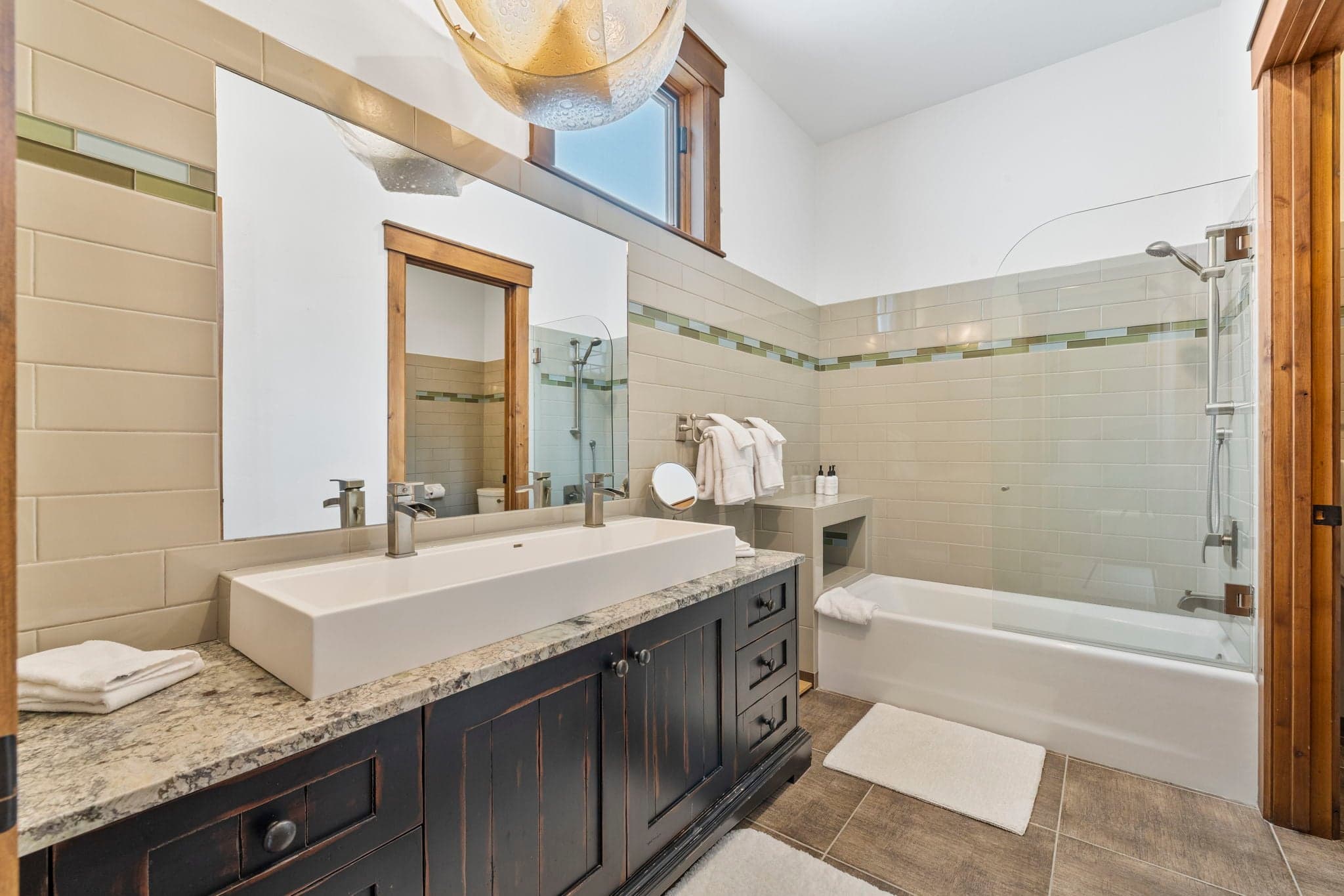 guest en suite bathroom with large sink and double faucets and a tub and shower